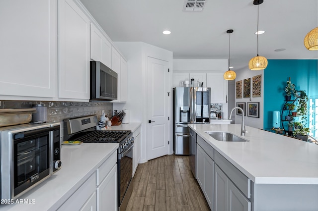 6145 S Adelle, Mesa, AZ 85212 - kitchen featuring appliances with stainless steel finishes, a sink, light countertops, wood finished floors, and recessed lighting