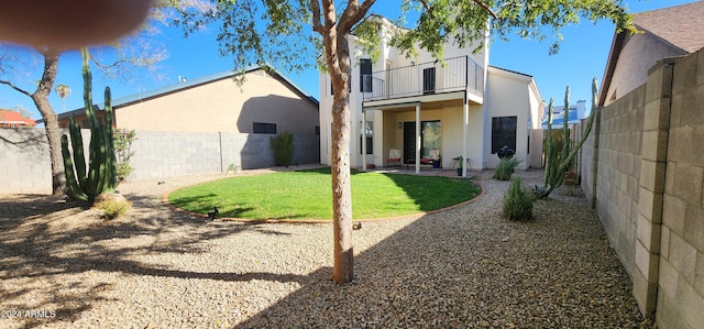 rear view of property with a lawn and a balcony