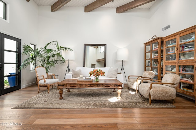 sitting room featuring wood ceiling, wood-type flooring, visible vents, and beamed ceiling