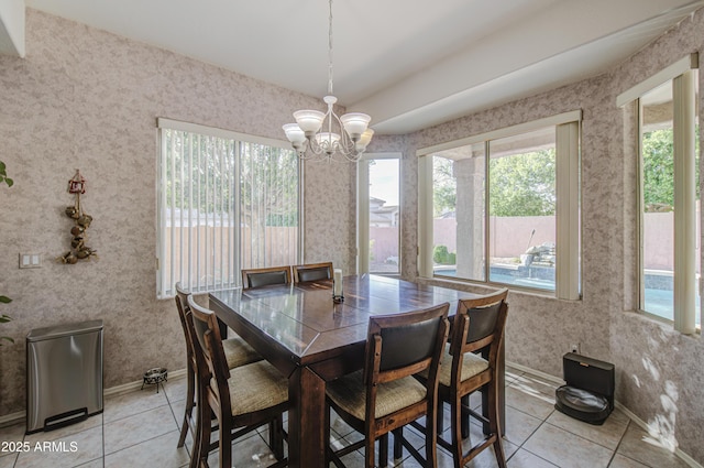 dining room featuring light tile patterned flooring, wallpapered walls, and a notable chandelier
