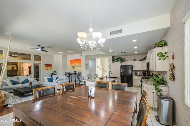 dining space featuring ceiling fan with notable chandelier and visible vents
