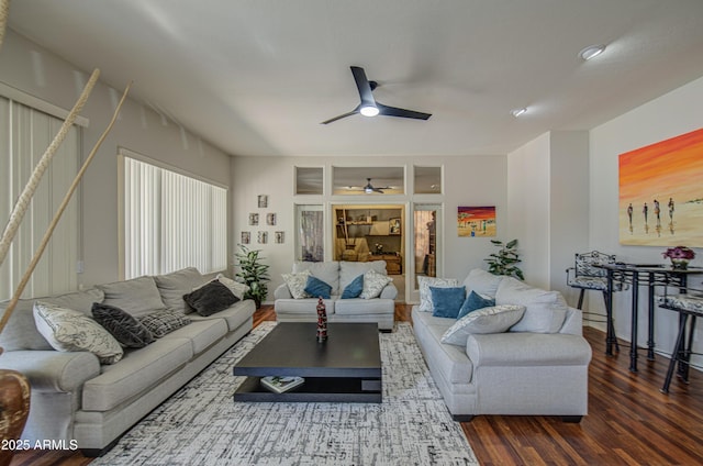 living room featuring ceiling fan, wood finished floors, and stairway