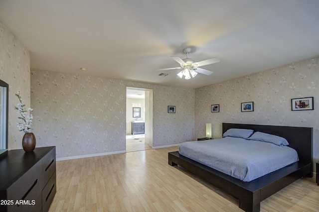 bedroom with light wood finished floors, a ceiling fan, wallpapered walls, baseboards, and visible vents