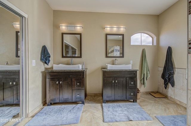 full bath with a sink and two vanities