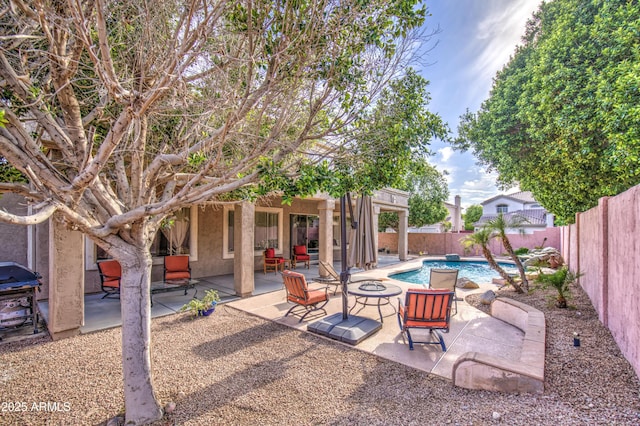 view of patio / terrace with a fenced in pool, a fenced backyard, a fire pit, and grilling area