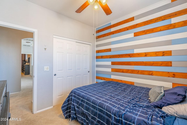 carpeted bedroom featuring ceiling fan and a closet