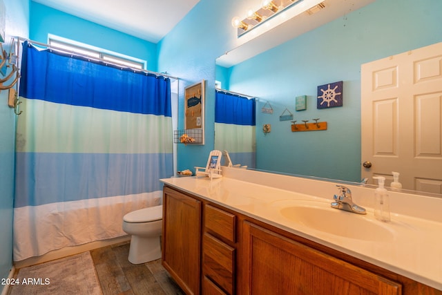 full bathroom with shower / bathtub combination with curtain, hardwood / wood-style floors, vanity, and toilet