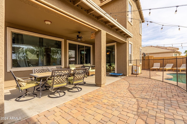 view of patio / terrace featuring a fenced in pool and ceiling fan