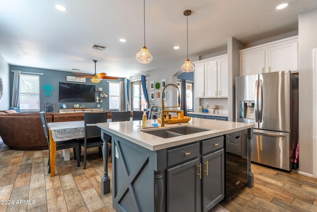 kitchen featuring gray cabinetry, a kitchen island with sink, hardwood / wood-style flooring, white cabinets, and stainless steel fridge with ice dispenser