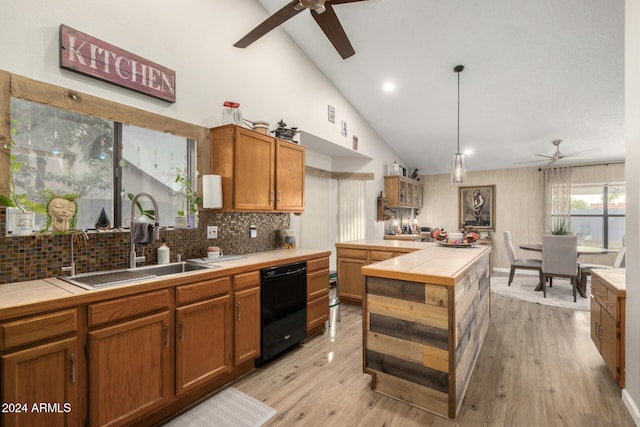 kitchen with sink, black dishwasher, tile countertops, light hardwood / wood-style floors, and pendant lighting