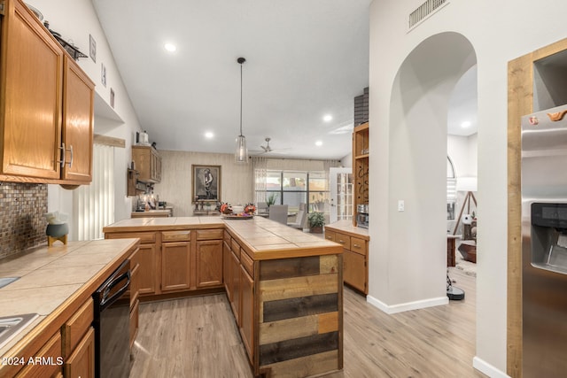 bar featuring black dishwasher, light hardwood / wood-style flooring, tile counters, and ceiling fan