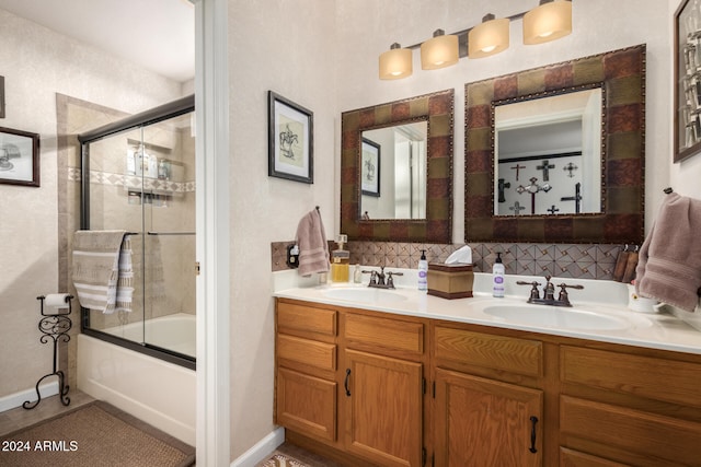 bathroom with backsplash, vanity, and bath / shower combo with glass door