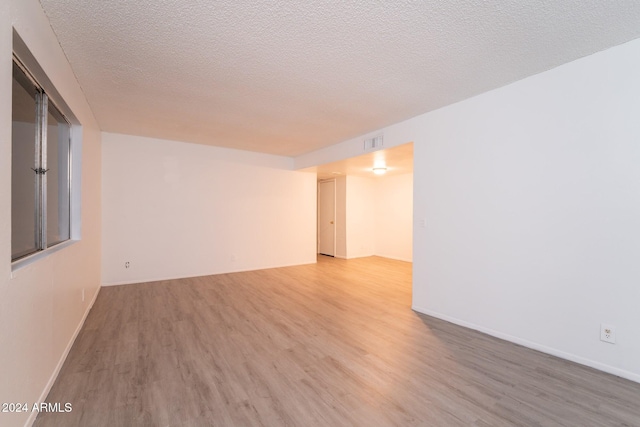 empty room featuring a textured ceiling and hardwood / wood-style flooring