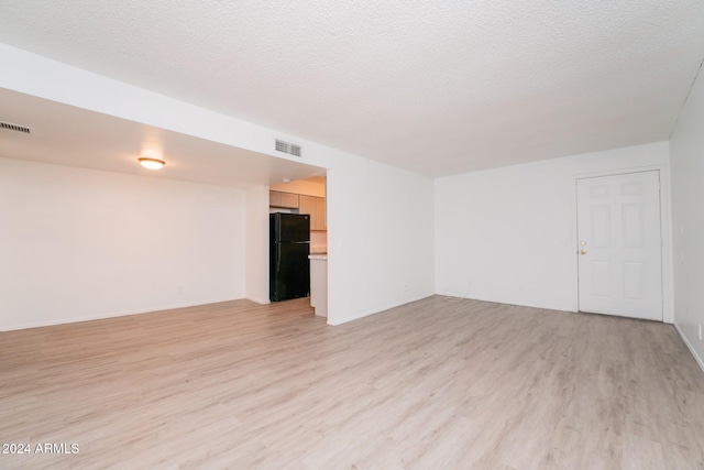 empty room featuring light hardwood / wood-style floors and a textured ceiling