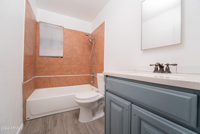 full bathroom with vanity, toilet, tiled shower / bath, and hardwood / wood-style floors