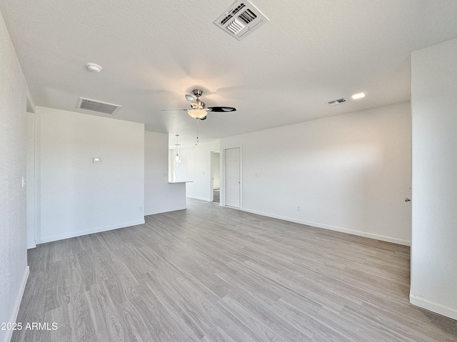 spare room with ceiling fan, light hardwood / wood-style floors, and a textured ceiling