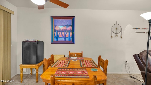 dining area featuring ceiling fan, baseboards, and light tile patterned flooring