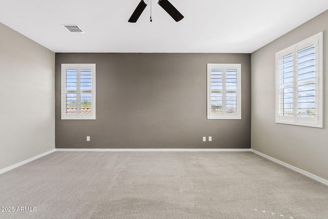 spare room with plenty of natural light, visible vents, baseboards, and carpet