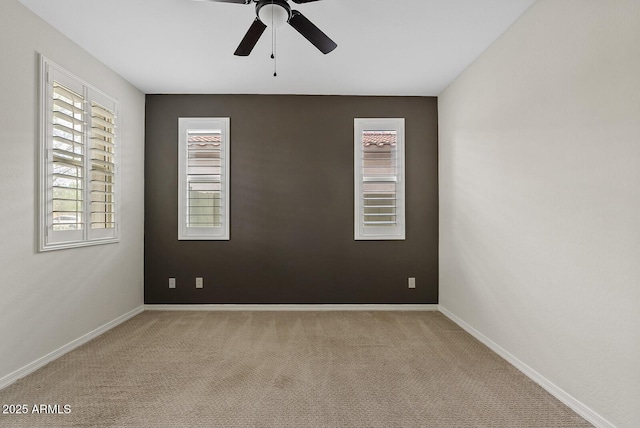 empty room featuring baseboards, carpet, and a ceiling fan