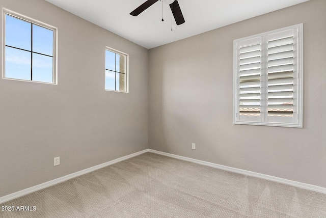 empty room with carpet flooring, ceiling fan, and baseboards