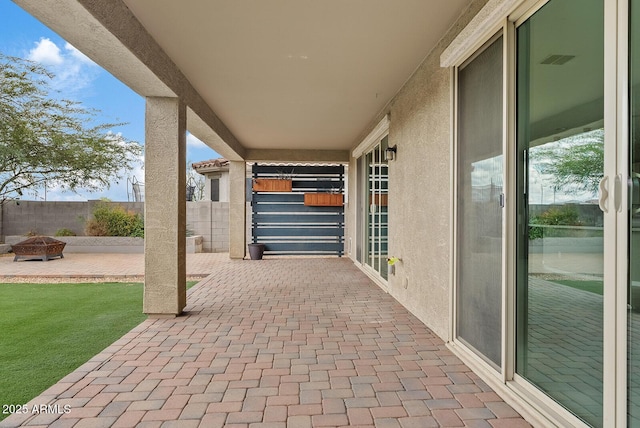 view of patio with visible vents, a fire pit, and fence