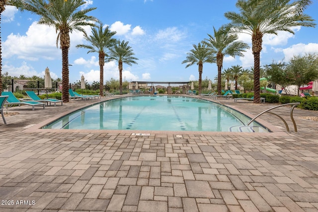 pool with a patio and fence