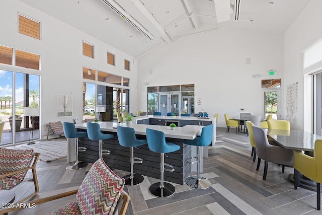 dining room with beam ceiling and high vaulted ceiling