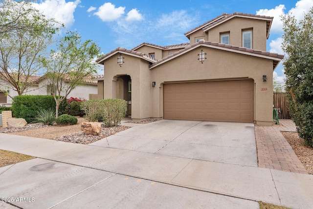 mediterranean / spanish-style house featuring a tiled roof, stucco siding, driveway, and fence