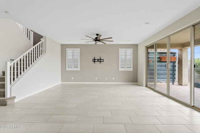 unfurnished room with ceiling fan, stairs, and baseboards