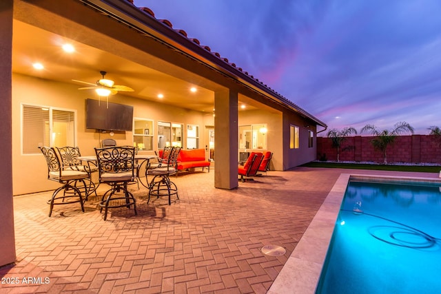 view of swimming pool with ceiling fan, a patio area, fence, and a fenced in pool