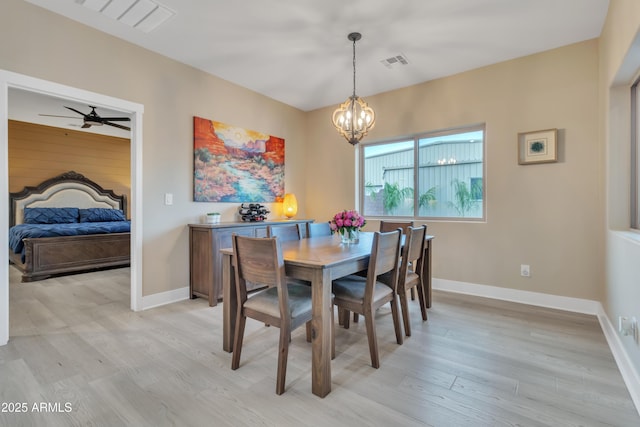 dining room with light wood-type flooring, baseboards, visible vents, and ceiling fan with notable chandelier