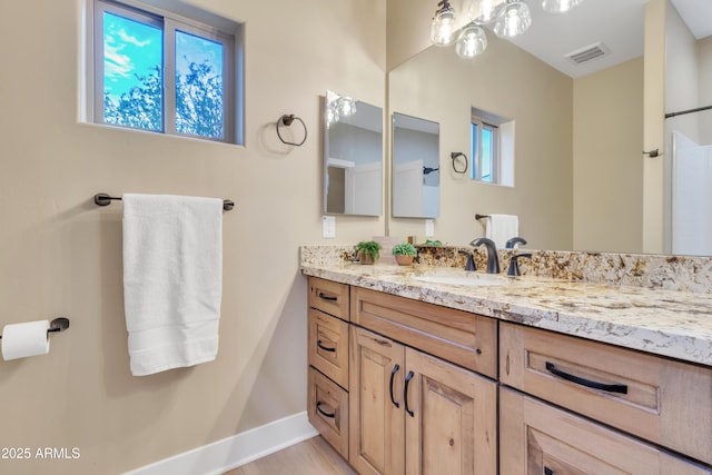 bathroom featuring baseboards, visible vents, and vanity