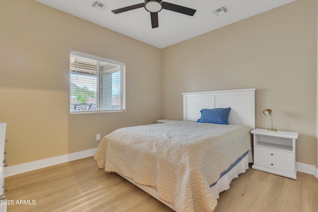 bedroom featuring a ceiling fan, visible vents, light wood-style flooring, and baseboards