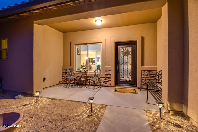 property entrance featuring a patio area and stucco siding