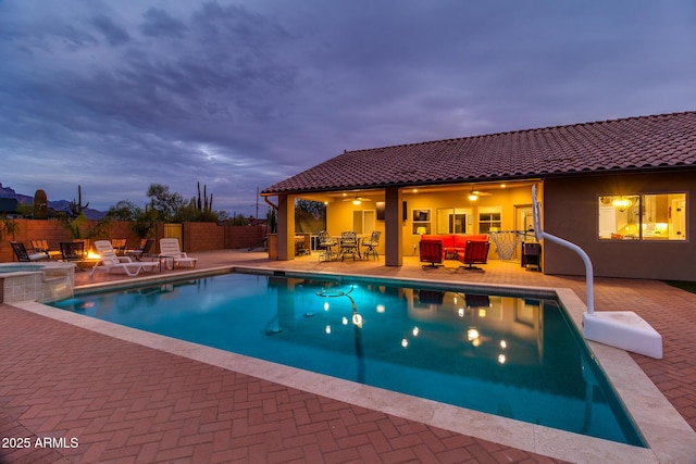 view of swimming pool with ceiling fan, an outdoor fire pit, a patio area, and fence