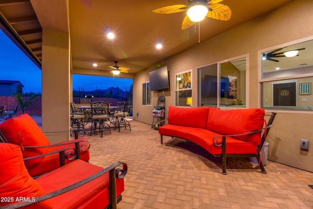 view of patio with outdoor dining space, fence, an outdoor living space, and a ceiling fan