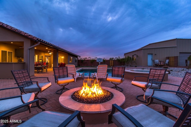 view of patio / terrace with a fenced backyard, a fire pit, a fenced in pool, and an outdoor structure