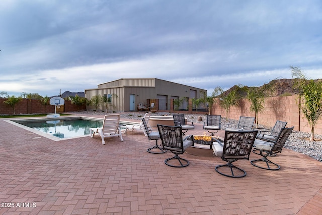 view of swimming pool featuring a fenced in pool, an outdoor fire pit, a fenced backyard, and a patio