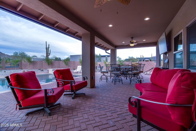 view of patio with ceiling fan, outdoor dining space, a fenced backyard, and a pool