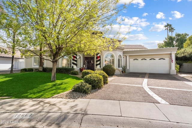 view of front of property featuring a garage and a front lawn