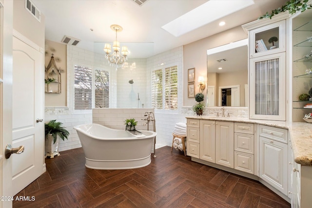 bathroom featuring vanity, an inviting chandelier, a skylight, parquet flooring, and tile walls