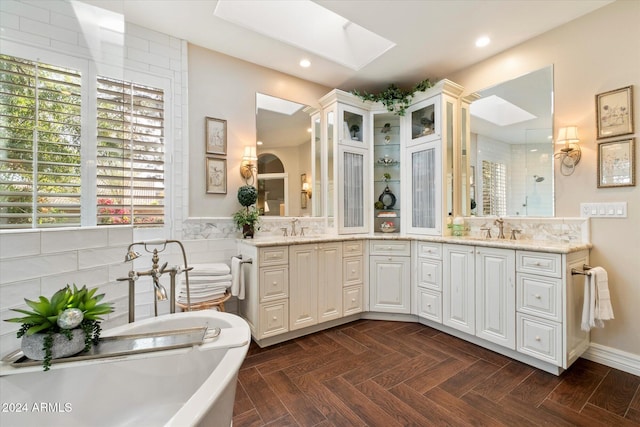 bathroom featuring vanity, a skylight, parquet floors, and independent shower and bath