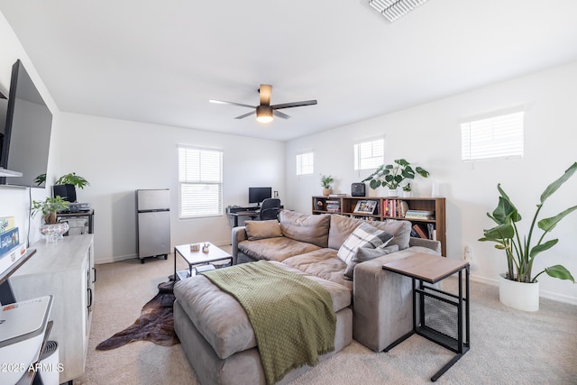 carpeted living room with ceiling fan and a wealth of natural light