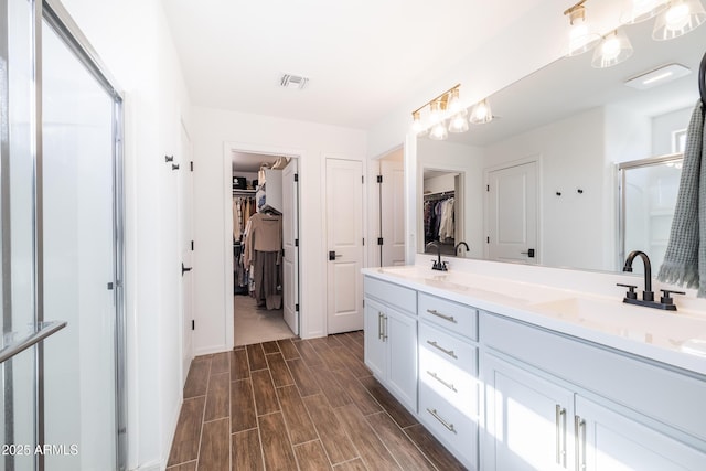 bathroom with a shower with door and vanity