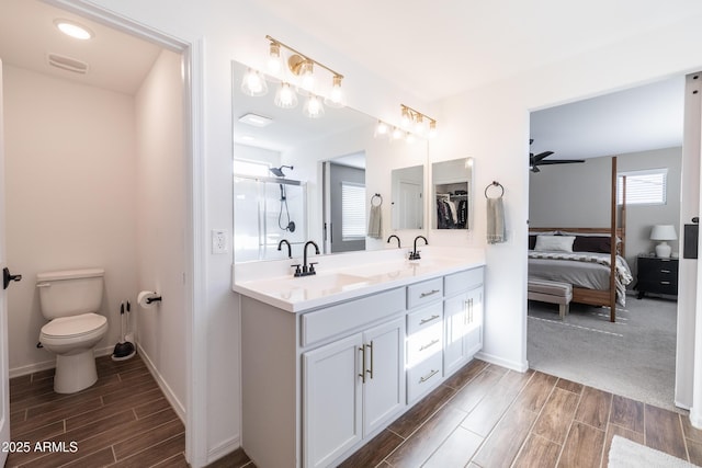 bathroom with toilet, ceiling fan, and vanity