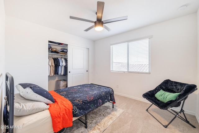 bedroom with ceiling fan, a closet, and light carpet