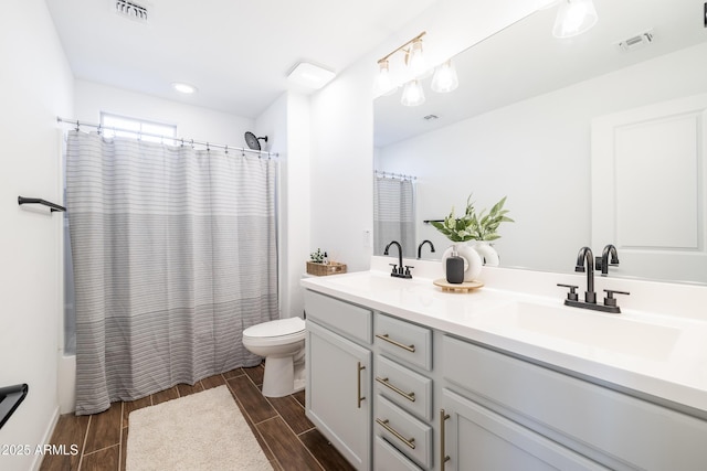 full bathroom with shower / bath combination with curtain, vanity, and toilet