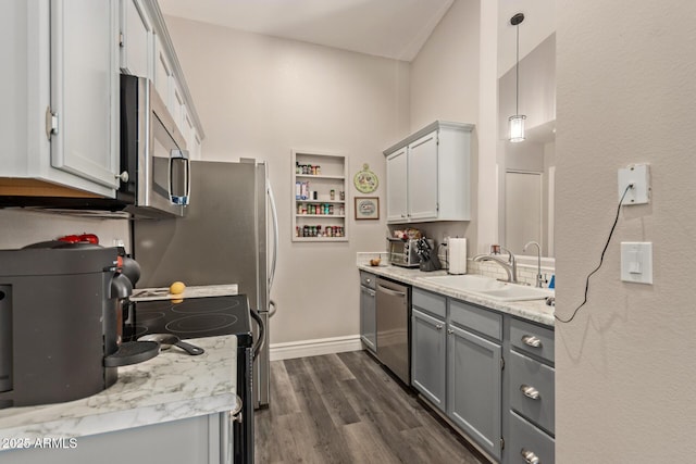 kitchen with sink, gray cabinets, appliances with stainless steel finishes, dark hardwood / wood-style floors, and decorative light fixtures