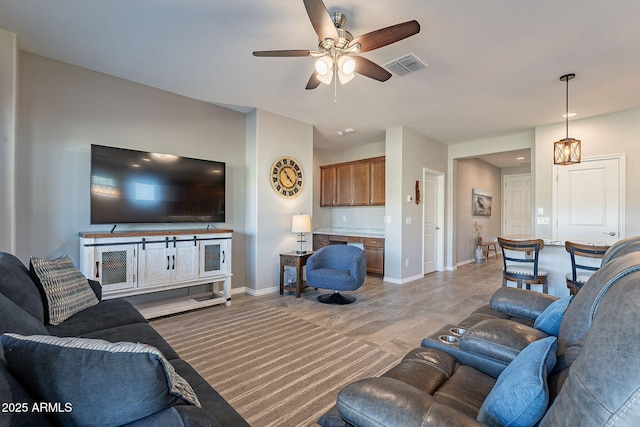 living room featuring ceiling fan, light hardwood / wood-style floors, and built in desk