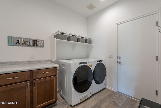 laundry area with separate washer and dryer, cabinets, and light hardwood / wood-style floors